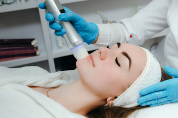 Naklejka premium Cosmetology clinic. Professional cosmetologist conducts cell oxygenation for the face. Beauty facial treatment. Lifting effect.