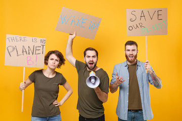 Displeased protesting young people hold protest signs broadsheet placard scream in megaphone...
