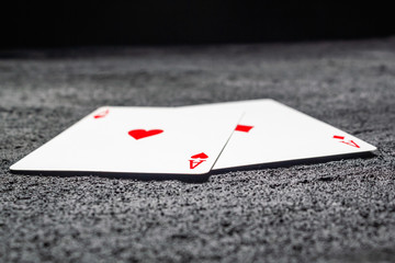 two red aces heart and diamond on black concrete dark background .copy space