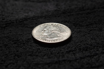 quarter dollar on black concrete dark background .copy space