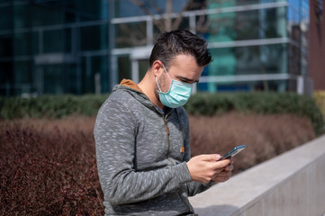 Men using phone in face mask on the street	