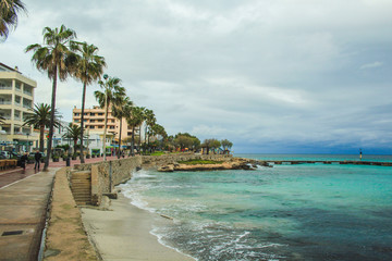 Cala Millor, Mallorca / Spain - March 24 2018: Only a few people walking along the promenade in Cala Millor, which is a famous tourist spot in summer