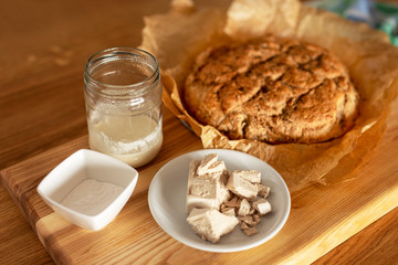 yeast for baking. Dry yeast, pressed yeast and homemade yeast (sourdough) on an oak table next to freshly baked bread.