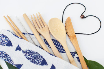 eco set of wooden bamboo cutlery and a bamboo drinking can in a fabric bag close-up