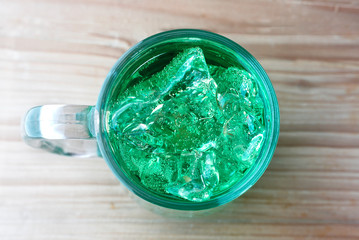 Top view a glass of italian lamon soda with ice on wood table background.