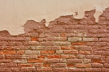 Fototapeta premium Old brick wall with peeling plaster.