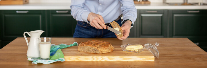 A man in a official shirt cuts freshly baked homemade bread