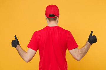 Back rear view delivery man in red cap blank t-shirt uniform gloves isolated on yellow background...