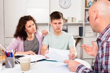Parents with teenager son reading documents