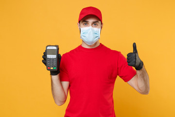 Fototapeta na wymiar Delivery man in red cap blank t-shirt sterile mask gloves isolated on yellow background studio Guy employee hold bank payment terminal Service quarantine pandemic coronavirus virus 2019-ncov concept