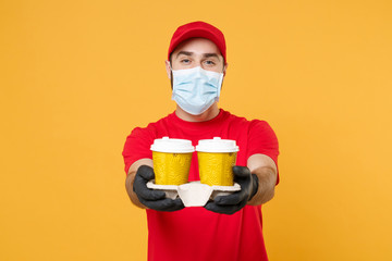 Delivery man in red cap blank t-shirt uniform mask gloves isolated on yellow background studio Guy...