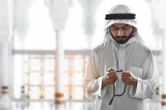 Religious arab muslim man praying with rosary beads