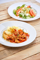 chicken with mashed potatoes and salad on the wooden background