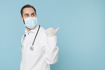 Side view of male doctor man in white medical gown sterile face mask gloves isolated on blue...