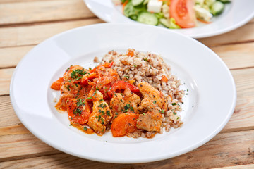 meat with buckwheat and salad on the wooden background