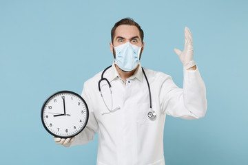 Angry male doctor man in medical gown sterile face mask gloves isolated on blue background....