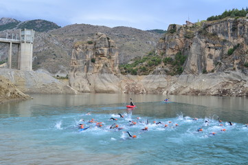 Triathletes swimming in a swamp in a triathlon, Canales, Granada, Spain