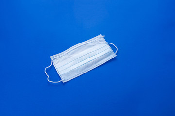 Face mask against viruses on a blue background. Prevention against viruses. Coronavirus.