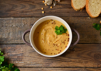 Pea cream soup in a bowl on a wooden background. Pea puree and porridge. Top view
