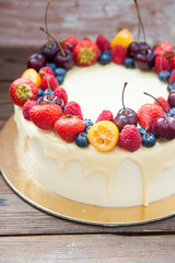 Cheesecake with white chocolate, fresh berries, strawberries, cherries, blueberries and raspberries on wooden background