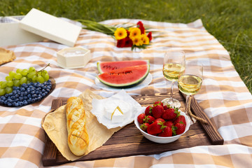 Romantic picnic in nature. The beauty of the setting sun, fresh fruits and wine.