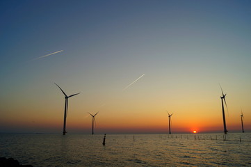 Sonnenuntergang im Windpark und die Flugzeuge sind die Sternschnuppen