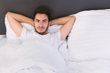 Young handsome man sleeping in his bed.