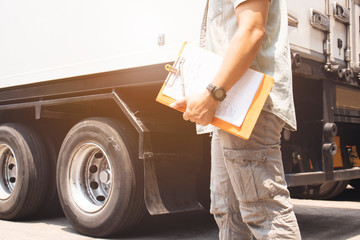 Truck driver holding clipboard inspecting safety check a truck, vehicle maintenance checklist a...
