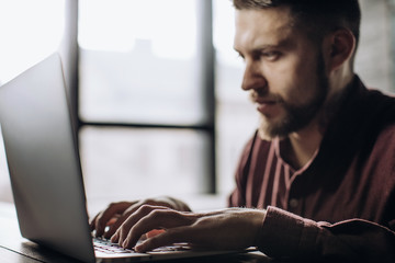 young man working on laptop computer at home, freelancing concept