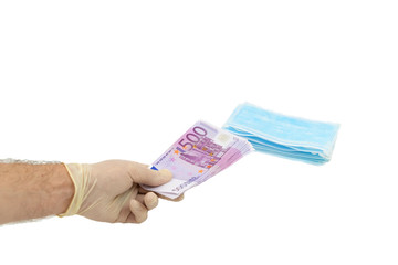 One hand in white protective gloves buys a pack of blue medical masks for money with 500 Euro...
