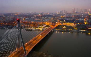 Warsaw on Vistula river with Swietokrzyski Bridge in evening