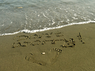 Words Don't Worry, footprints and wave on beach sand