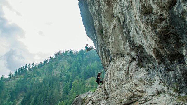 two climbers finding the way on a vertical cliff. Climbing area Burjakove peci