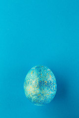 Easter egg painted blue with gold.