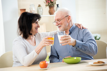 Happy elderly couple having breakfast together