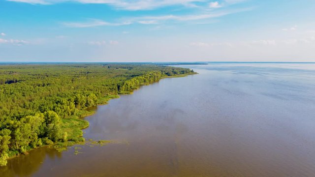 drone hyperlapse: moving forward over the green northern forests on the bay