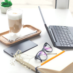 A table in a bright cafe with latte and freelancer work details.