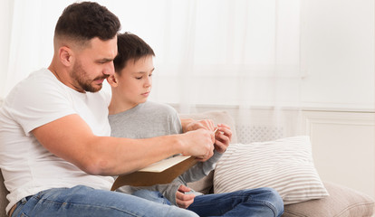 Dad reading book to his son, panorama, free space