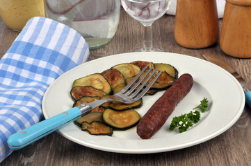 Rondelles de courgette et merguez servies dans une assiette en gros plan