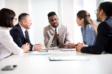 Young african-american businessman explains to colleagues a new project in the office