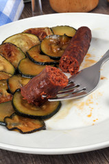 Rondelles de courgette et merguez servies dans une assiette en gros plan