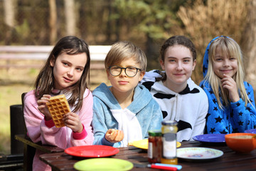 friends are laughing outside at breakfast on a sunny day
