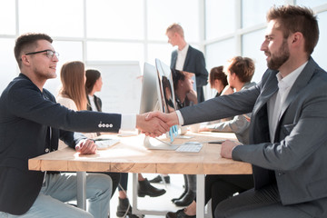 business colleagues shaking hands with each other at the meeting.