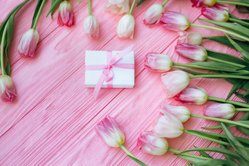 Wooden pink background and tulips with gift box. Flat lay. Conception holiday, March 8, Mother's Day.