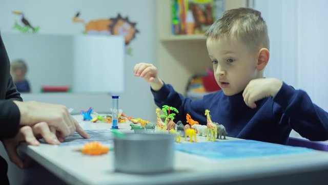 Little Boy with autism syndrome Learning homework And Playing games at Home on quarantine
