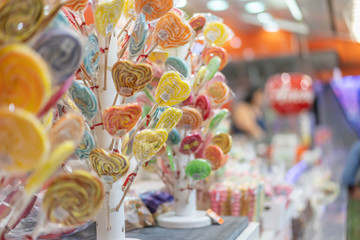 Variété de sucettes colorées sur un présentoir dans un stand de fête foraine