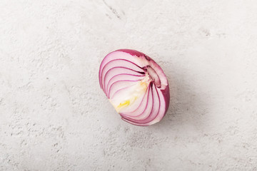 red onion sliced in half on a gray background