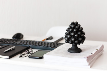 Home office, modern workplace: white table, keyboard laptop computer, concrete holder with pencils and pens, notebook, smartphone, glasses, paperweight with documents, education concept background.