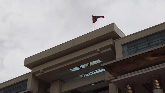 Parliament building in Ulan Bator, Mongolia in slow motion. Flag of Mongolia on top.