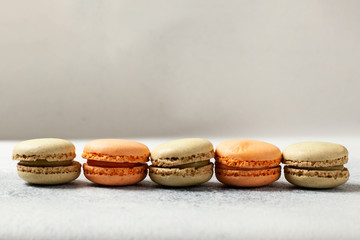 Mixed of Colorful Macarons cake on white concrete background with copy space. Green and orange french macaroons.